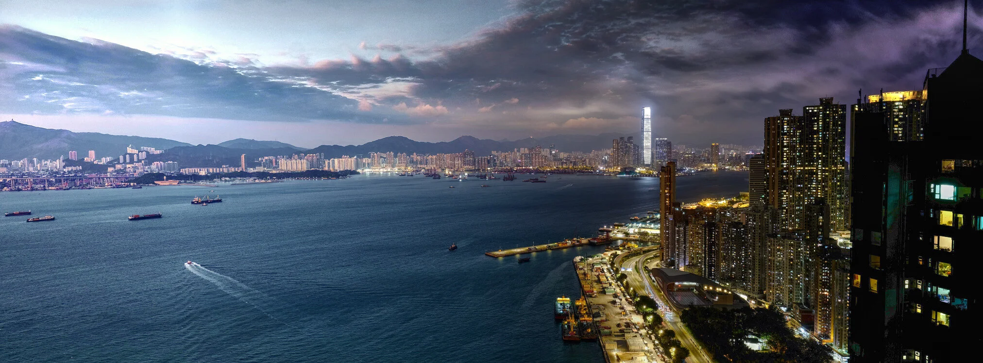 Dark storm clouds over a distant city and sea