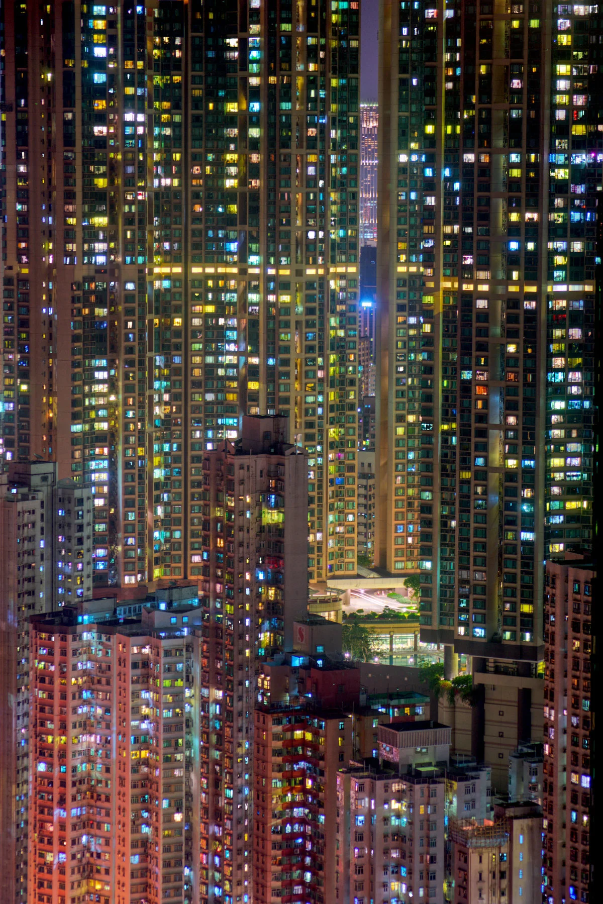 Dense residential towers glowing against a dark mountain